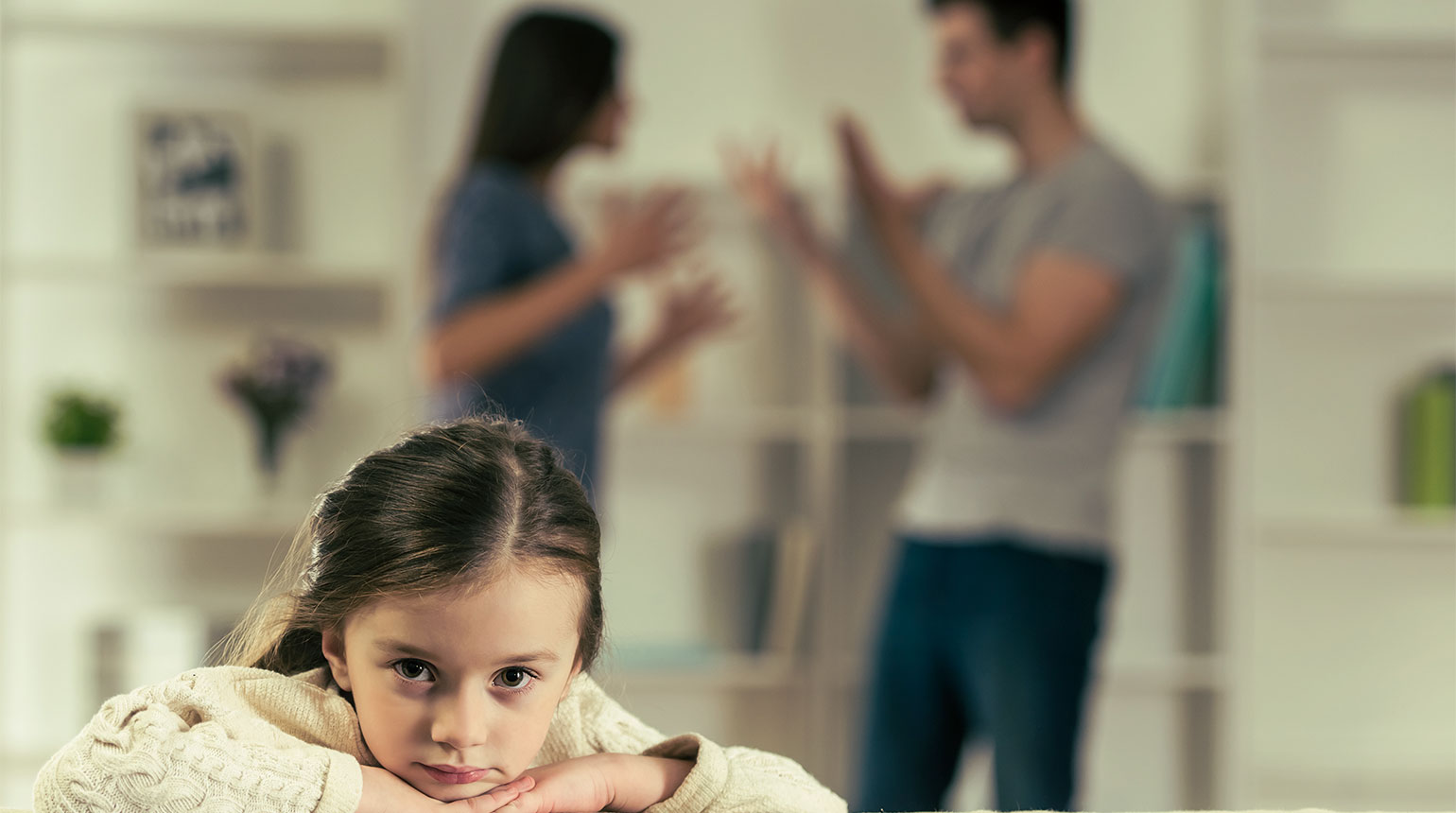 Im Wohnzimmer: Ein Kind erlebt bedrückt einen Streit zwischen seinen Eltern.