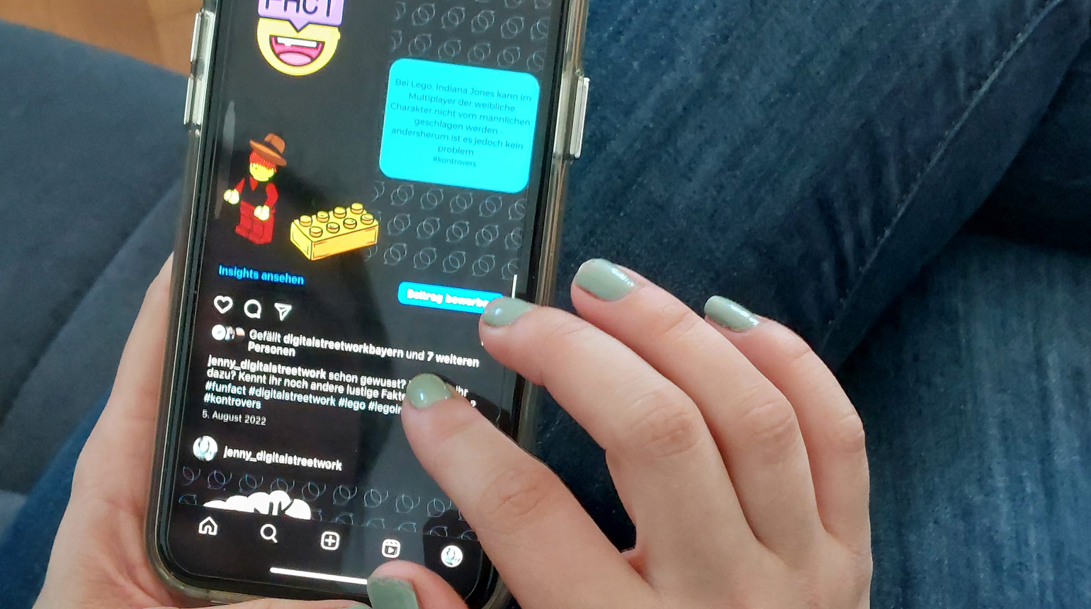 Nahaufnahme: Eine Hand scrollt auf einem Smartphone. Auf dem Display sind Game-Motive zu sehen. 