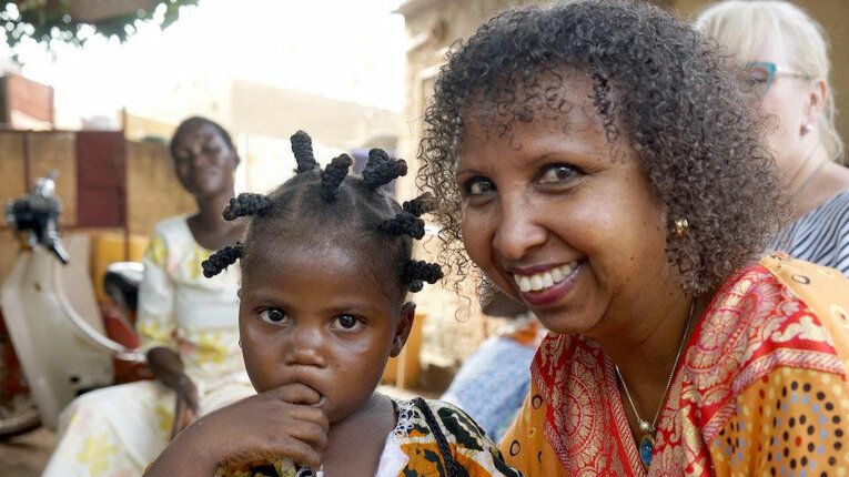 Porträtfoto: Fadumo Korn mit einem kleinen Mädchen.