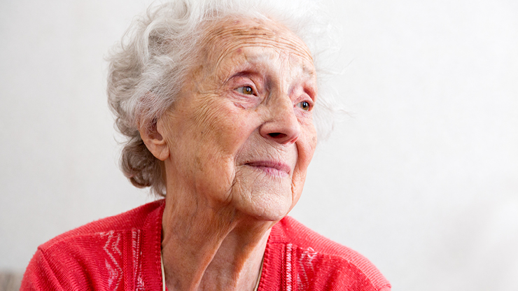 Porträtfoto: eine alte Dame. Sie blickt zur Seite, ins Leere.